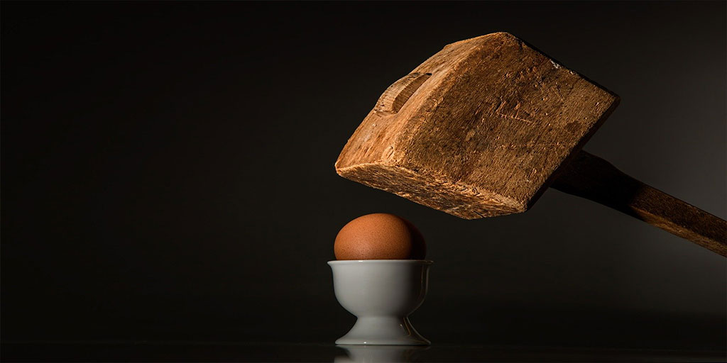 A mallet about to smash an egg