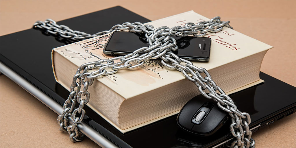 Laptop, book and mobile phone secured by chain