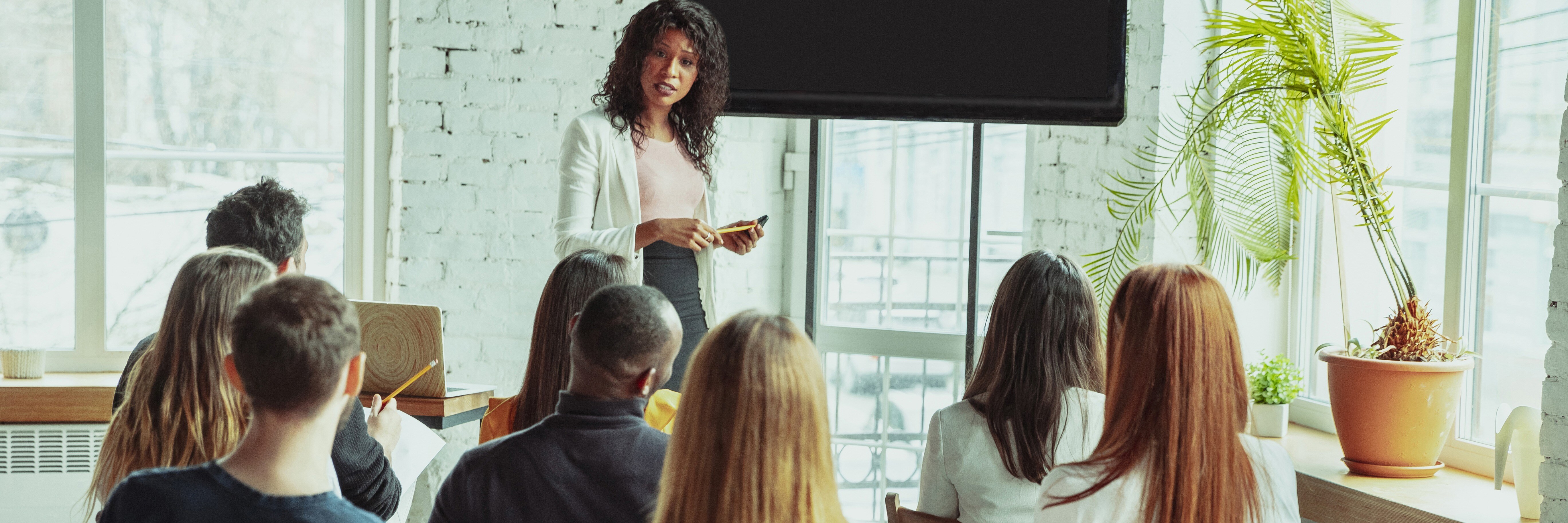 female-african-american-speaker-giving-presentation-hall-university-workshop (1)